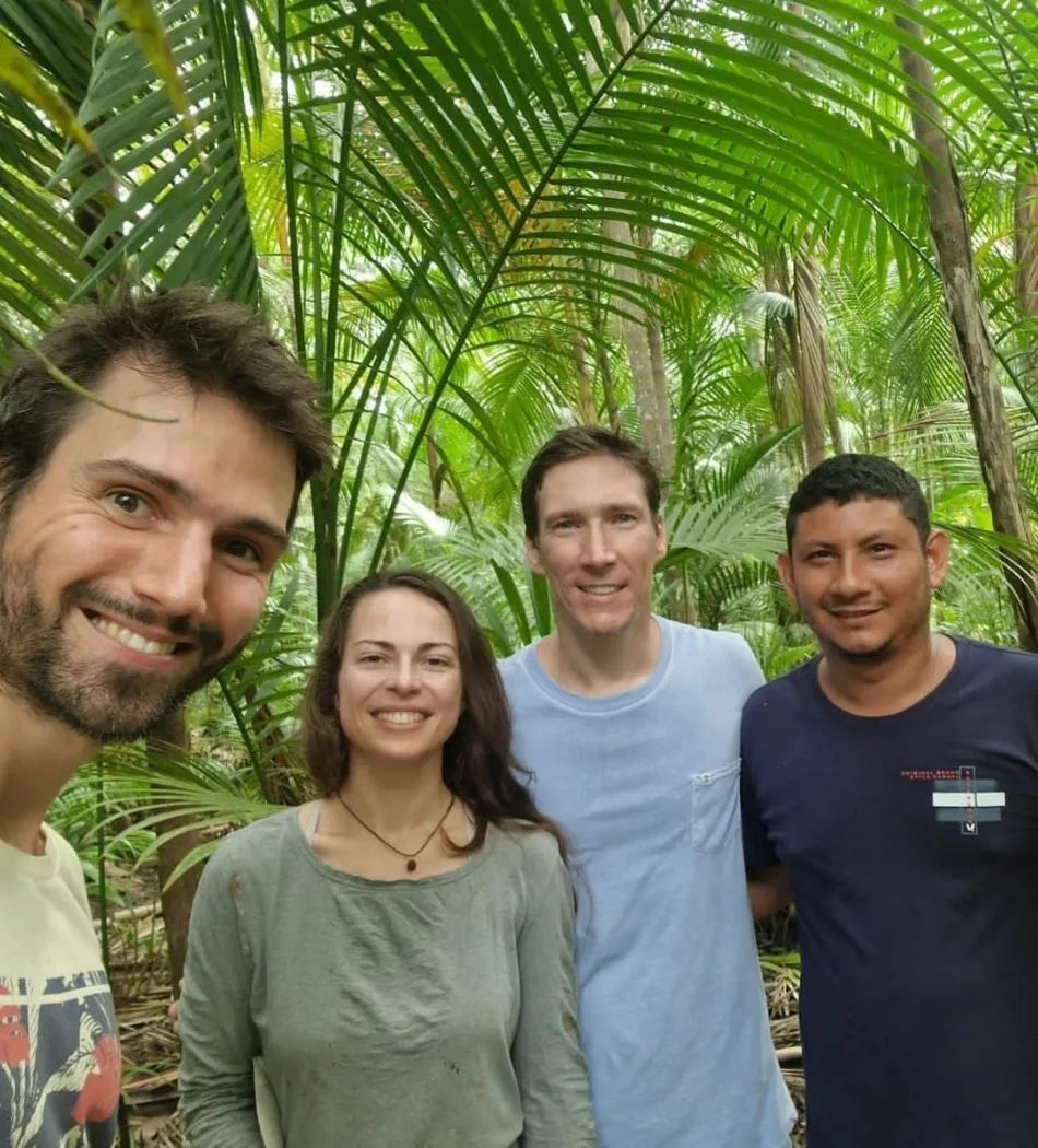 L'équipe de Nossa se tiennent dans la jungle, entourés de palmiers, en compagnie de producteurs d'acai