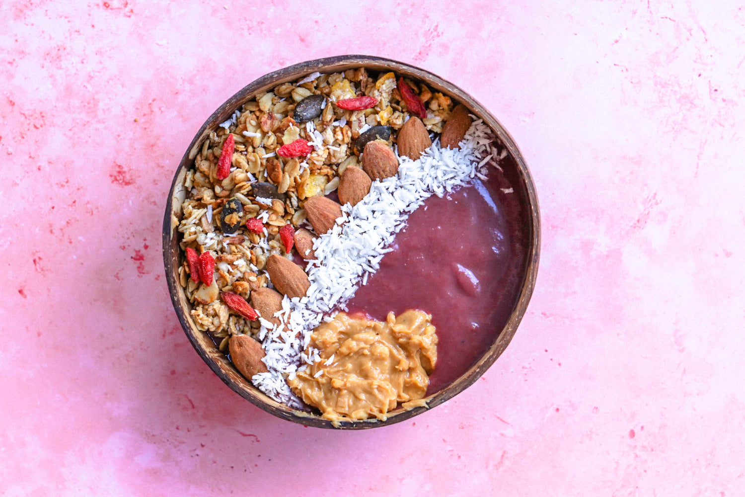 açai bowl avec topping granola, amande, et beurre de cacahuète